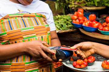 A young African woman trying to make payment with her credit card in the market