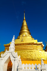 Fototapeta premium Golden Pagoda in thailand with lamp and umbrella thai Culture on nice blue sky