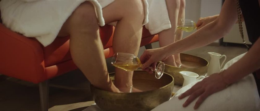 two masseuses giving a wine foot massage to a couple with the aid of a golden bowl - Zwei Masseusen geben einem Paar eine Wein Fu&szlig;massage mithilfe einer goldenen Sch&uuml;ssel