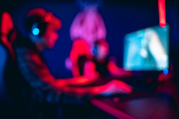 Blurred background professional gamer playing tournaments online games computer with headphones,...