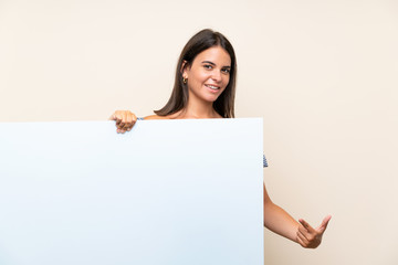 Young girl over isolated background holding an empty white placard for insert a concept