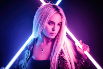 beautiful stylish fashionable girl in bodysuit posing in photo Studio on dark background in neon...