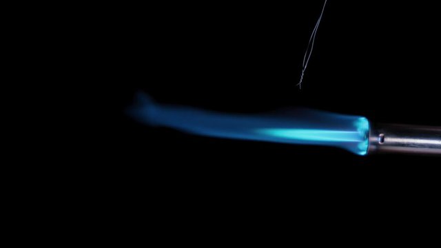 Butane gas burner flame burning from nozzle against black background. Welding tool with burner flame. Blue and Orange Flame from a butane blow torch. Closeup of butane burner.