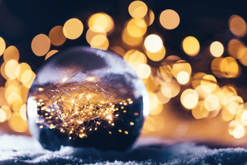 Christmas glass ball with a star inside on snow.