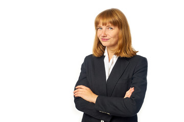 Image of young female office worker dressed in dark blazer and white shirt. Redheaded woman in business clothes looking at the camera and smiling