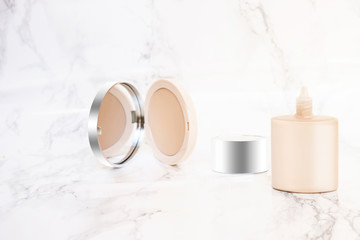 Foundation concealer cream tube with silver lid and powder isolated on modern pastel marble backdrop. Advertising Banner for smooth clean skin, flat lay for cosmetics, mock up bottle. Horizontal photo