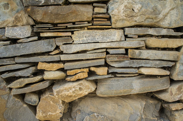 The texture of the stone. Masonry fence. A variety of stone textures in different colors, sizes and shapes.