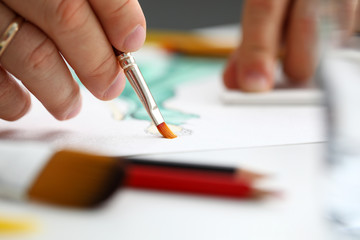 Male hand making drawing with watercolor brush