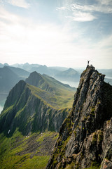 Adventurous man is standing on top of the mountain and enjoying the beautiful view during a vibrant...