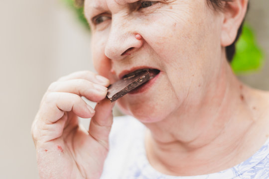 Senior Woman Eating Chocolate