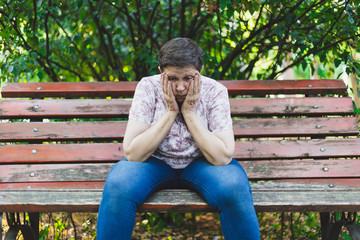 Sad senior woman sitting alone