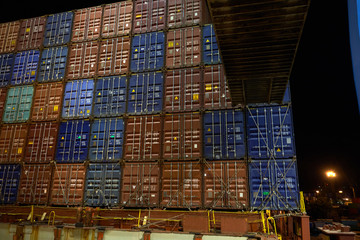 Containers stack on ship deck. Container loading in Cargo freight ship with industrial crane at sea port. Container ship in import and export business. Industry and Transportation concept.