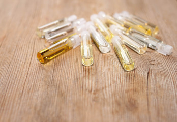 Group of small glass bottles on wooden background. Perfume testers or chemical samples.