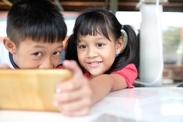 Girls and boys enjoy playing on the smartphone