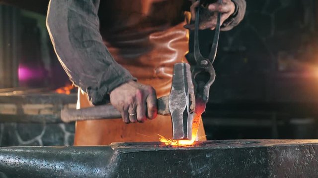 Iron is getting forged by a blacksmith in slow motion