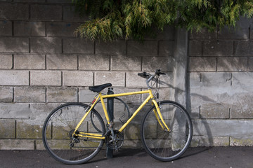 Fototapeta na wymiar un vélo jaune posé contre un mur