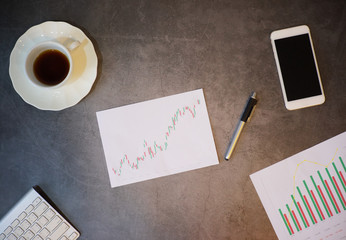 Financial or stock graph chart indicators analysis concept, top view work desk with chart analysis on paper