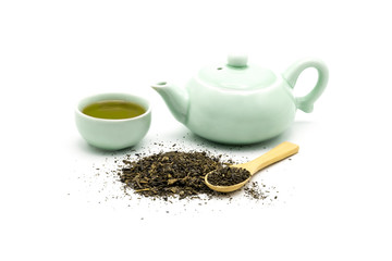 Green tea set with dry green leaves and wooden spoon isolated on white background.