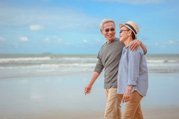 Senior couples embrace the sunrise beach, plan life insurance with the concept of happy retirement.