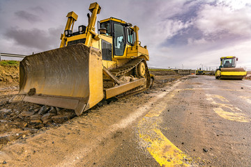 Excavator to level and smooth the land in the construction of a road