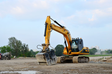 Excavator with crusher bucket for crushing concrete. Construction waste recycling for construction mix. Sifting and grinding bucket for the separation of concrete into fractions of higher quality.