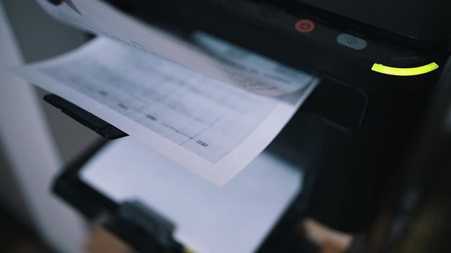 Woman office worker tacking printed document or papers from laser printer.