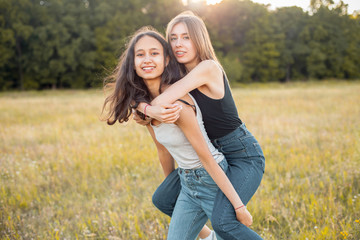 Two beautiful young women having fun outdoors under sunlight. Best friends