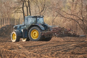 Tractor working on agricultural fields, trademarks removed and color scheme changed