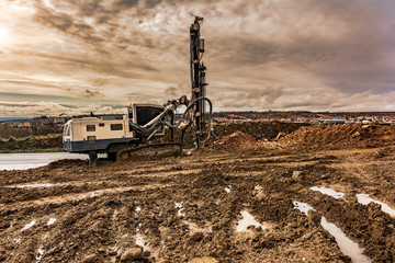 Obraz premium Industrial drilling machine in a construction site with mud