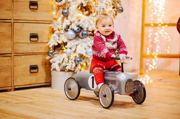 Happy fun child paying with little car at home on Christmas time. Xmas holiday concept