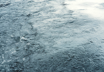 Water surface with ripples and sunlight reflections
