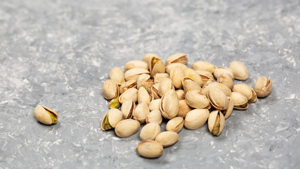 Heaps of pistachio nuts over concrete surface