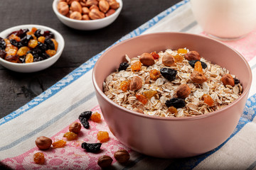 Oatmeal with raisins and nuts in a ceramic bowl on a black wooden table