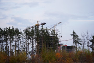 Modern building under construction with crane. Constructing building with high crane under clear sky