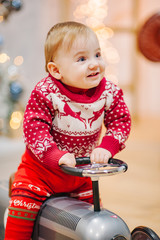 Happy fun child paying with little car at home on Christmas time. Xmas holiday concept
