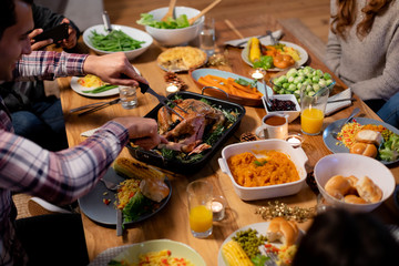 Millennial adult friends celebrating Thanksgiving together at home 