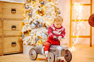 Happy fun child paying with little car at home on Christmas time. Xmas holiday concept