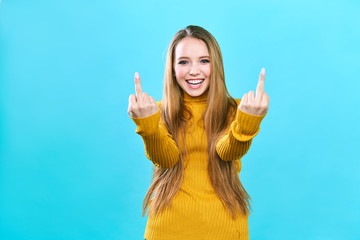 Young beautiful woman standing over isolated blue background Showing middle finger doing fuck you...