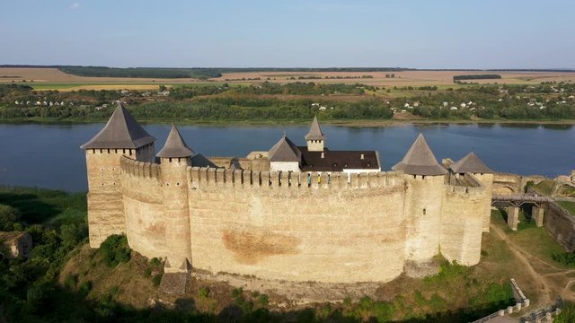 Aerial view of old castle near the River. Hotyn Castle in Ukraine. Eastern Europe. Zoom out.