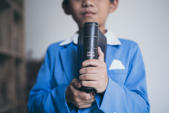 Little Asian Boy Pray With Bible In Classroom At School, Bible Study Concept