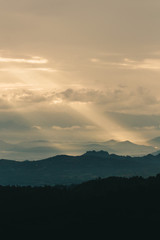 Beautiful sunrise in the mountains. Landscape with sun shining through orange clouds in Myanmar