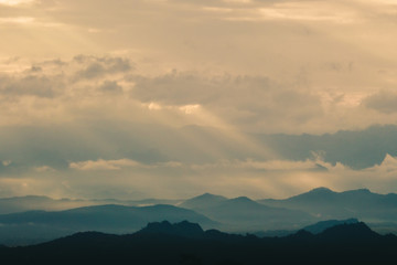 Fototapeta na wymiar Beautiful sunrise in the mountains. Landscape with sun shining through orange clouds in Myanmar