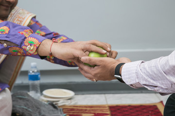 Fototapeta na wymiar Hinduism ceremony hands passing apples