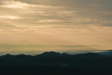 Beautiful sunrise in the mountains. Landscape with sun shining through orange clouds in Myanmar