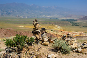 Fototapeta na wymiar stones pyramids on the background of the Altai mountains red hills