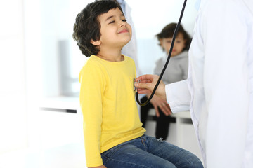 Doctor examining a child patient by stethoscope. Cute arab boy at physician appointment. Medicine and healthcare concept