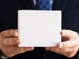 Close-up elegant man holding up small box