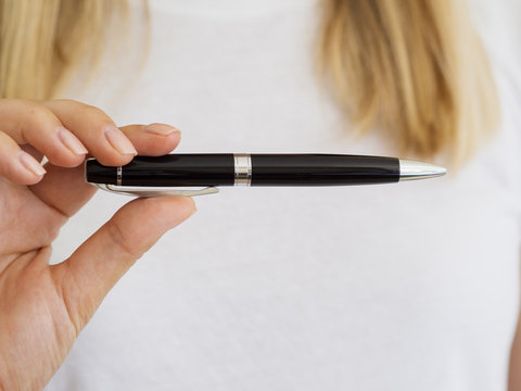 Close-up person holding up elegant pen