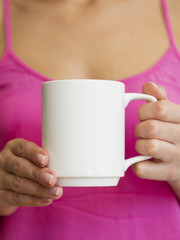 Close-up woman with pink shirt and mug