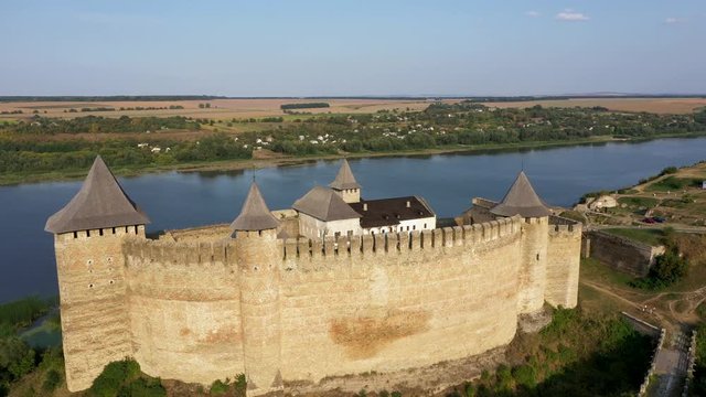 Aerial view of Hotyn medieval castle on the green hill above the river. Zoom out.